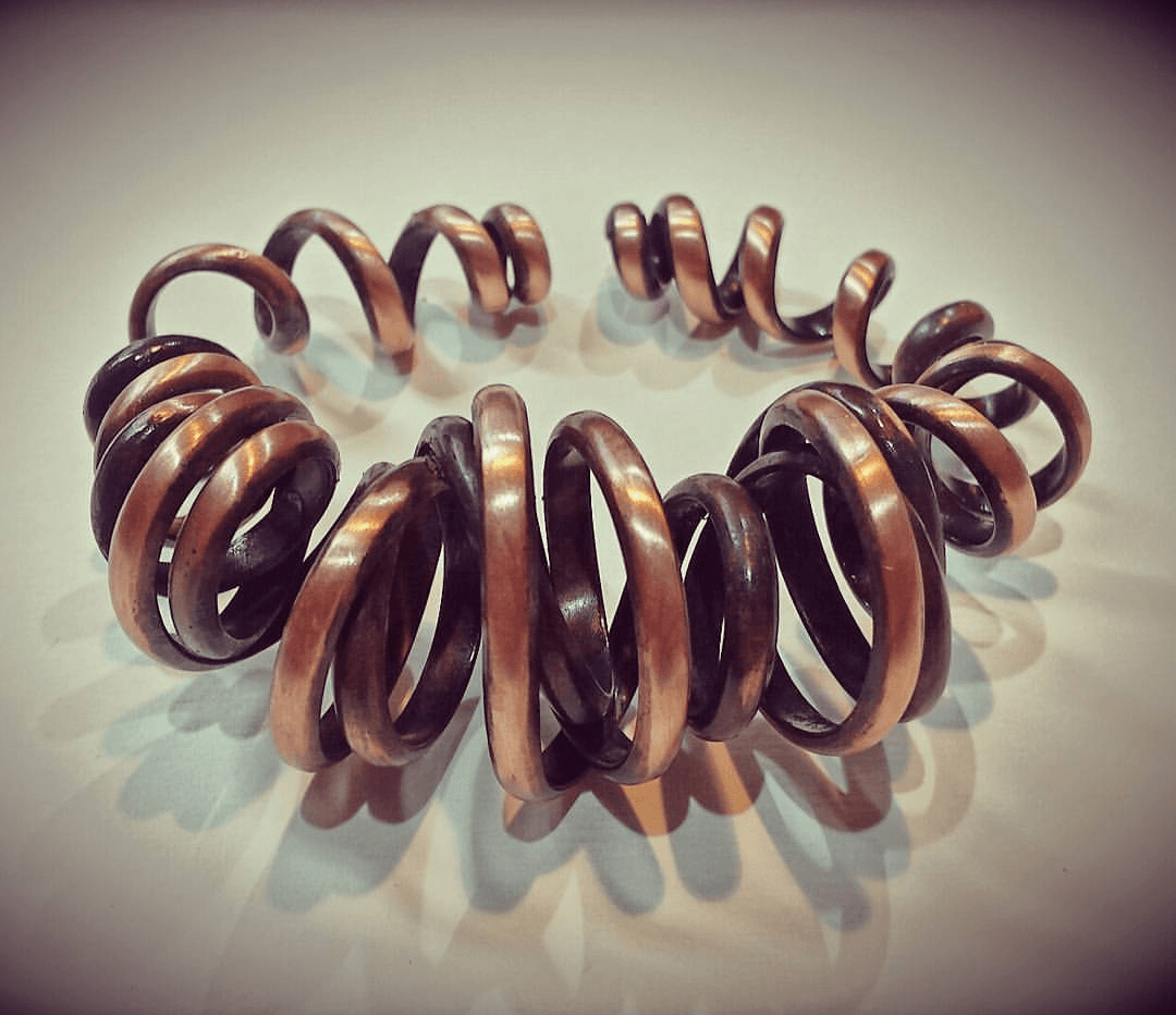 Primer plano de un brazalete de cobre perteneciente a la colección Espiral Cobre de Amparo Valencia