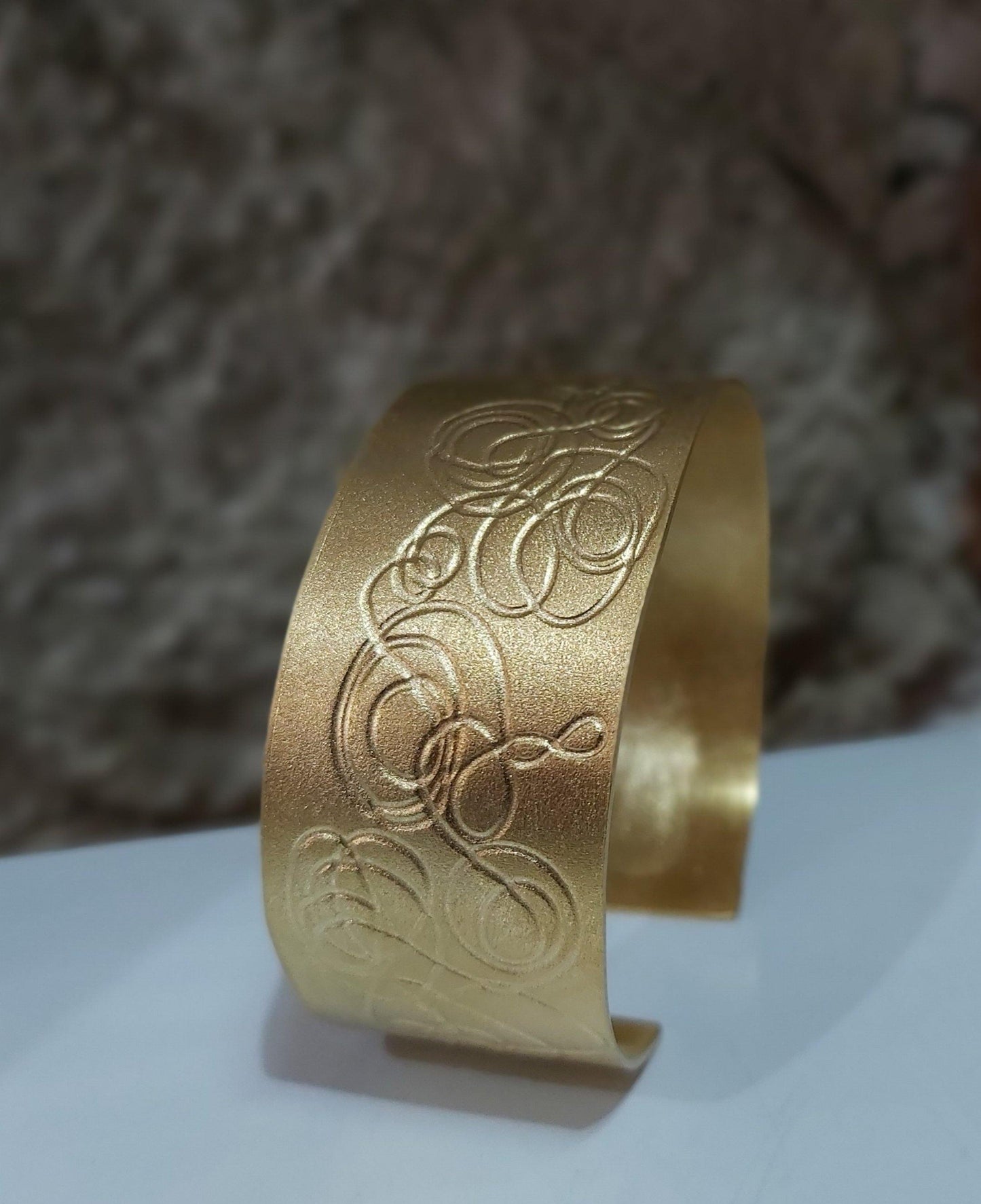 Brazalete exclusivo chapado en oro con grabado original. Hecho a mano por Amparo Valencia. de la colección Trazos . Joyería artesanal en Barcelona