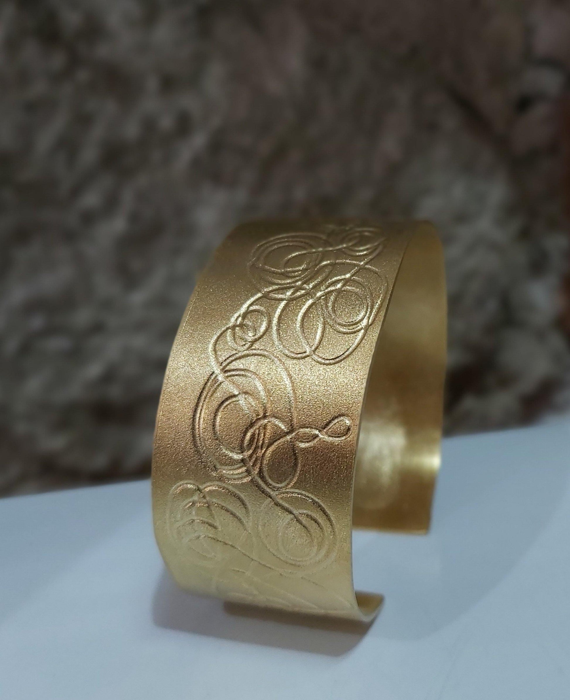 Brazalete exclusivo  chapado en oro con grabado original. Hecho a mano por Amparo Valencia. de la colección Trazos . Joyería artesanal en Barcelona
